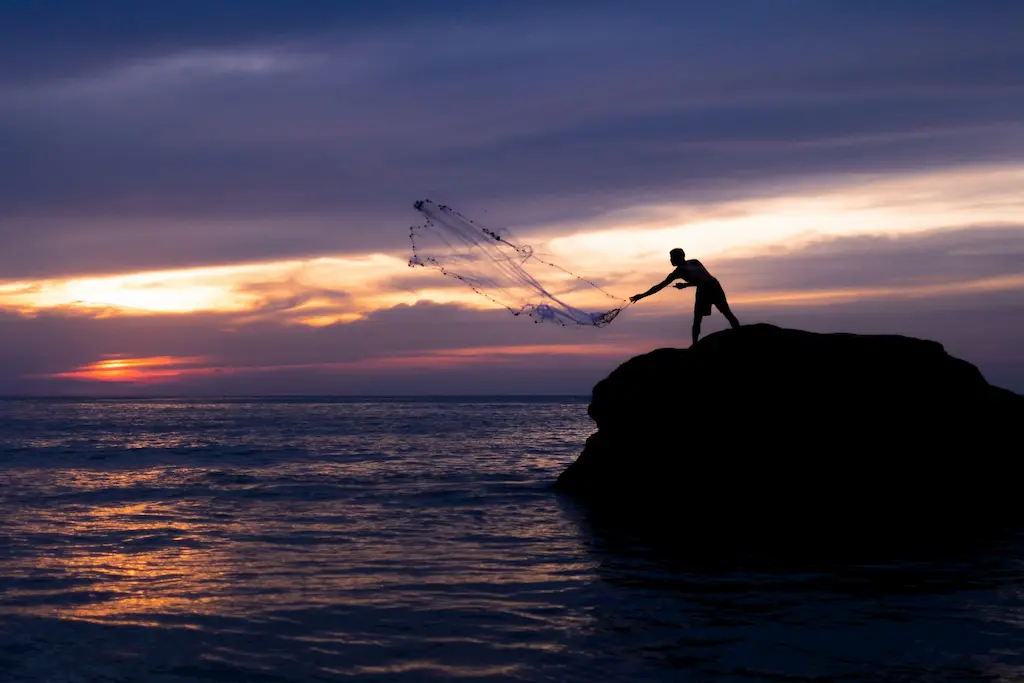 Silhouette of a fisherman casting his net